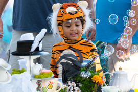 Child laughing at bubble machine while trick or treating