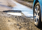 car wheel next to pothole in the road