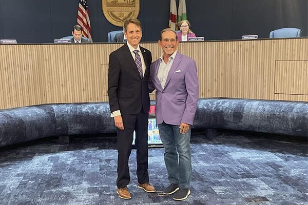 Executive Director Drew Bartlett passed the purple jacket to Governing Board Member Charlie Martinez