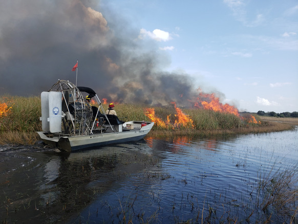 staff conducting prescribed burns from an airboat