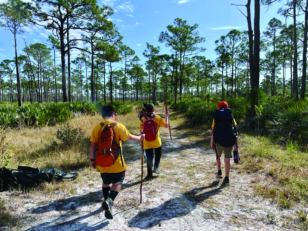 A group of three people hiking in a natural area