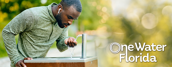 Athletic man drinking from water fountain