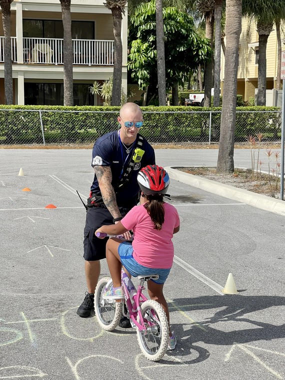 Treasure Island Bike Rodeo with firefighter watching a chiled in bike obstacle course