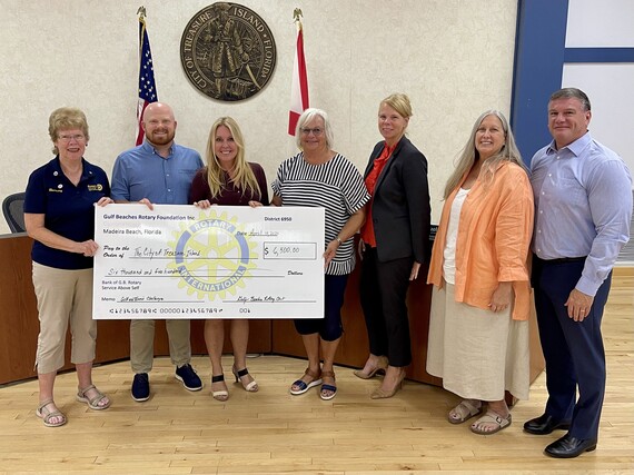 Rotary Club members pictures with City Commission and check