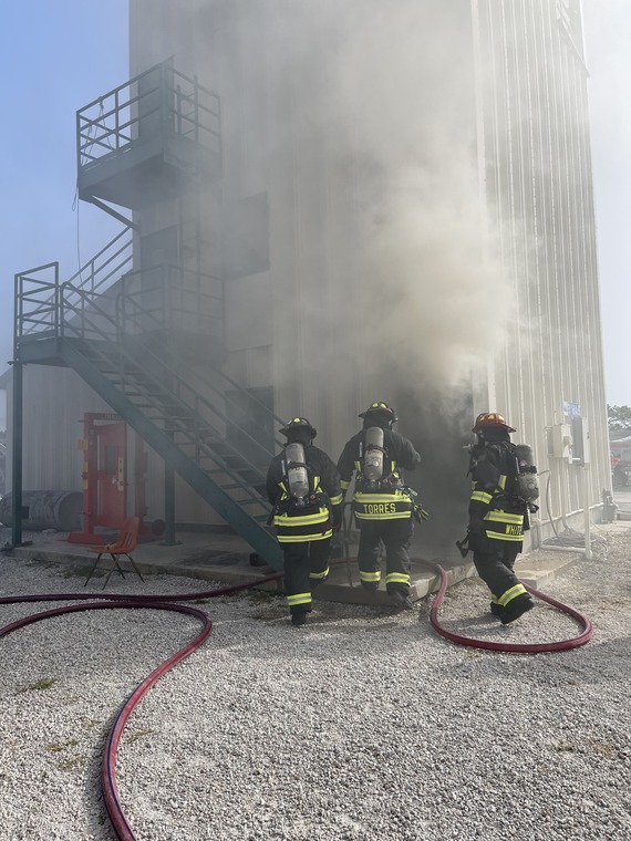 Treasure Island Firefighters using hose to spray a burning building in training