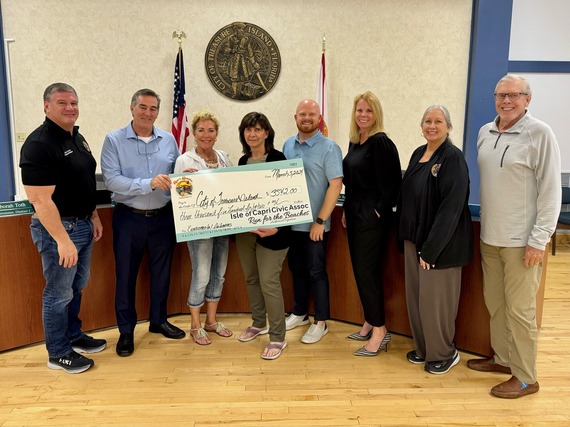 Isle of Capri and Run for the Beaches Association present a check to the city of Treasure Island