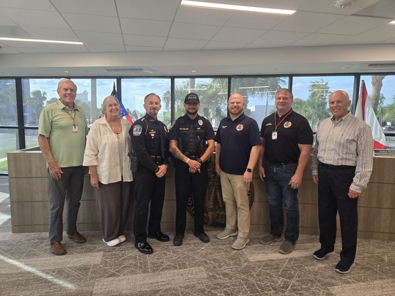 TIPD Officer Phillips posing with the City Commission and Police Chief