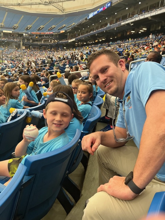 Assistant Parks and Recreation Director Mike Baker gives a fould ball he caught at a Rays game to a summer camper