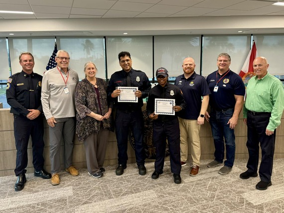 Two Treasure Island Fire Rescue workers posing with the city commission and their EMT awards