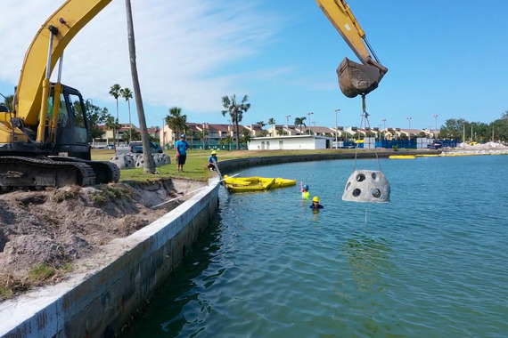 Oyster dome being lowered in water near Treasure Bay shoreline