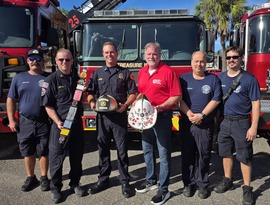 Tresure Island Fire Chief Barrs and Deputy Fire Chief Brennan post with gold helmet and other dignitaries