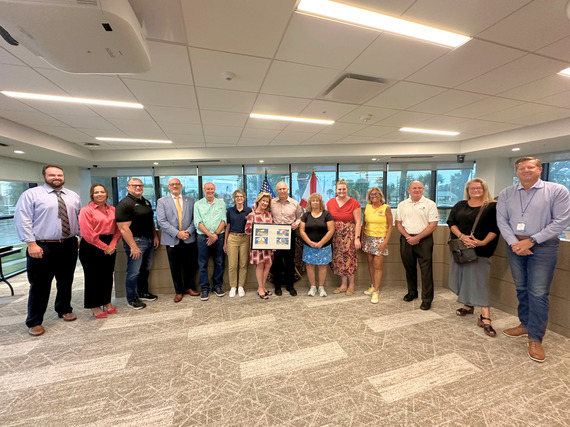 Treasure Island City Commissioners pictures with post-storm volunteers and their recognition award