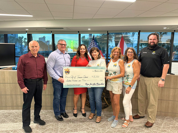 Run for the Beaches representatives posing with city commission after presented a check