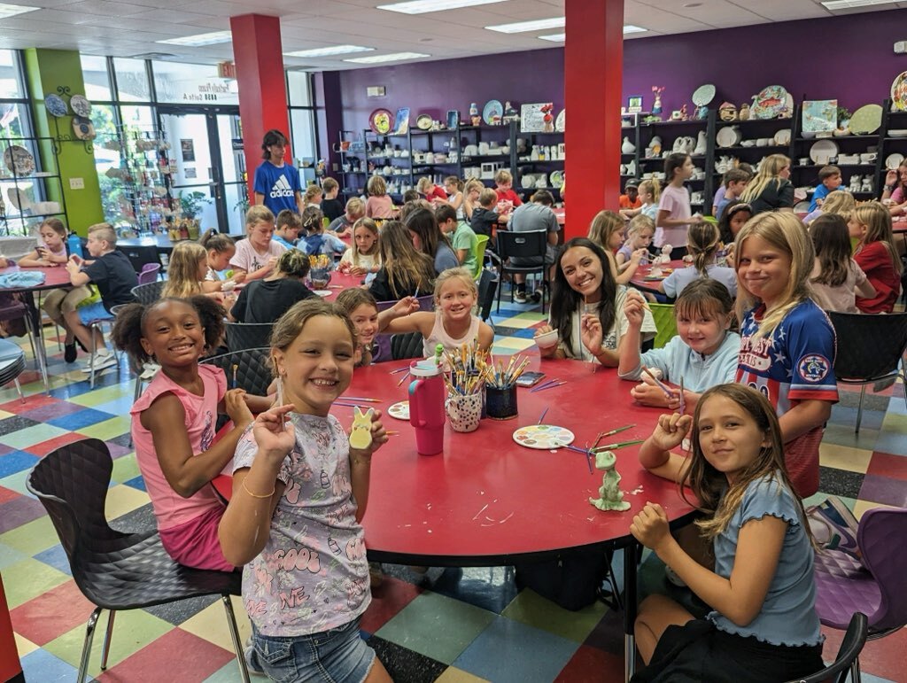 Treasure Island summer camp kids posing for picture with art supplies