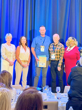 PIO with commissioners accepting award on stage