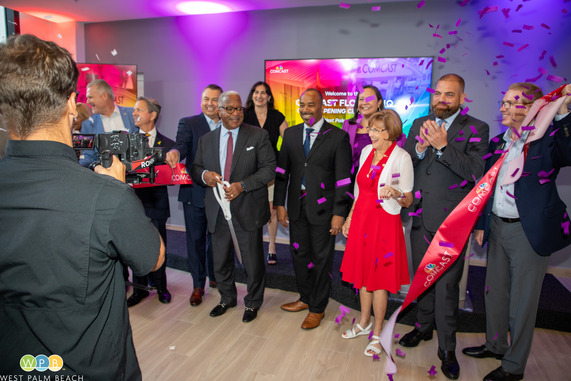 Mayor James cuts ribbon among group of people with confetti in the air 