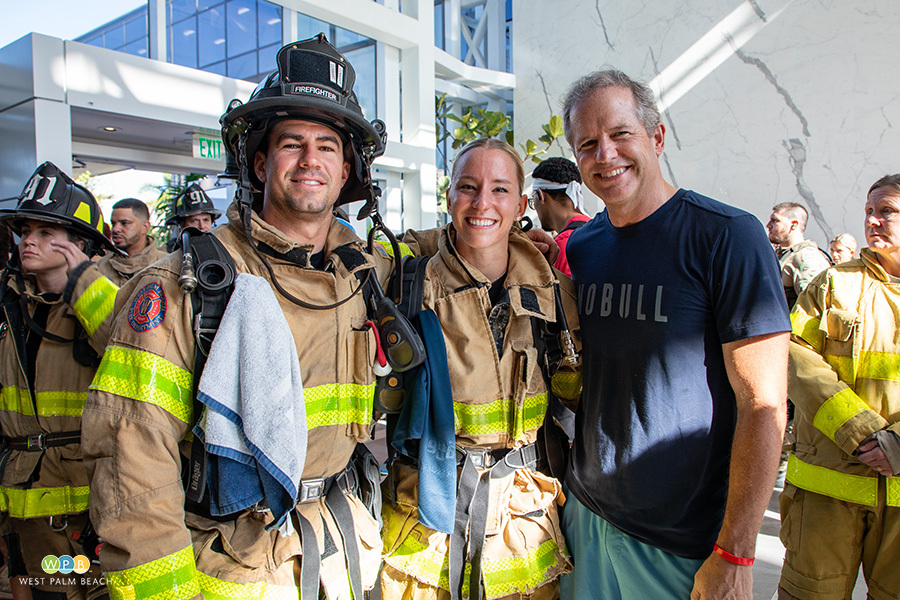 WPB team ready to climb, three people pose for a photo, two in firefighter gear