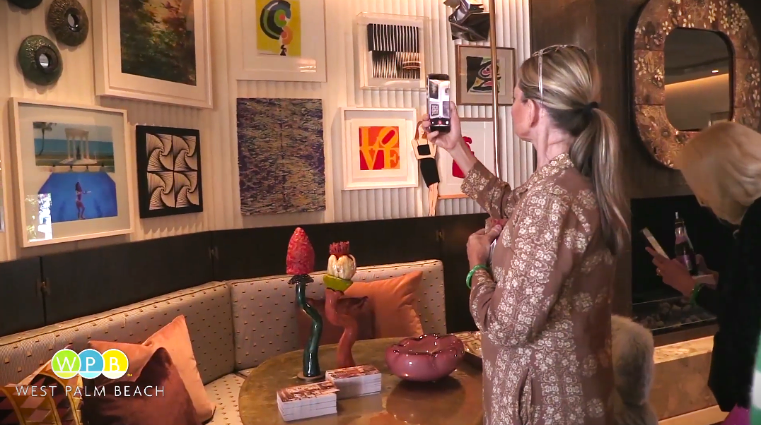 Woman takes a photo of interior design and art on the wall - WPBTV YouTube Video for Kips Bay Decorator Show House Benefits Boys & Girls Clubs