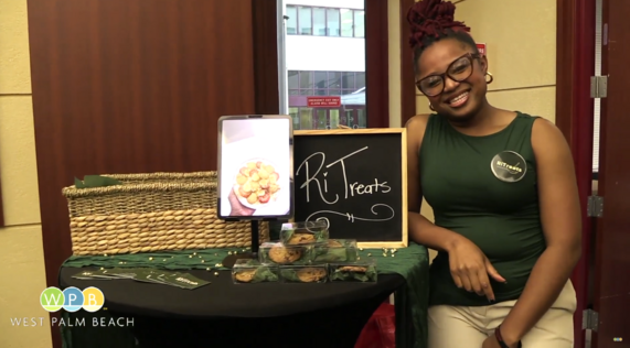 Mayor's Jumpstart Academy Graduate - woman smiling at a table with her business cards 