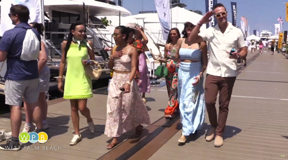 Palm Beach International Boat Show on the WPB Waterfront - people walking on board walk with boats in the background 
