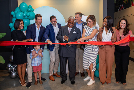 Spruce Ribbon Cutting with Mayor Keith James and others standing in front of a red ribbon ready to cut it!