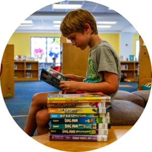 little boy reading a book in the Mandel public library