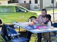Mandel Mobile Van and two people sitting at outdoor table working on a homework assignment for school
