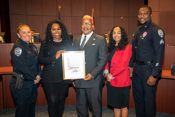 United Against Hate proclamation Held By Mayor James and 4 others in a group photo, including two police officers 