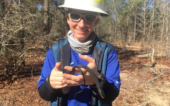 DNR’s Killian Farrell holds a young indigo found on coastal state lands. (Robert Horan/DNR)