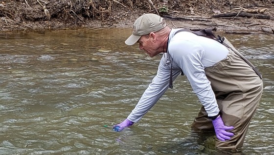 DNR's Peter Dimmick takes a water sample for eDNA (Ani Popp/DNR)
