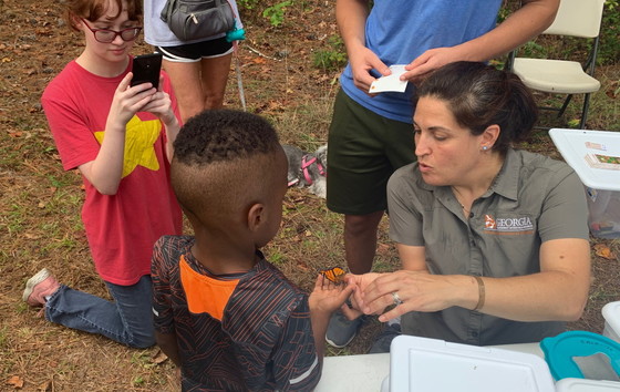 DNR's Anna Yellin helps a child release a monarch at Hard Labor Creek.  (Dan Shumlison)