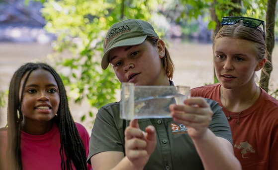 DNR's Jess Rath shows  Hutton Junior Fisheries Biology Program students a mosquitofish (Peter Turcik/AFS)