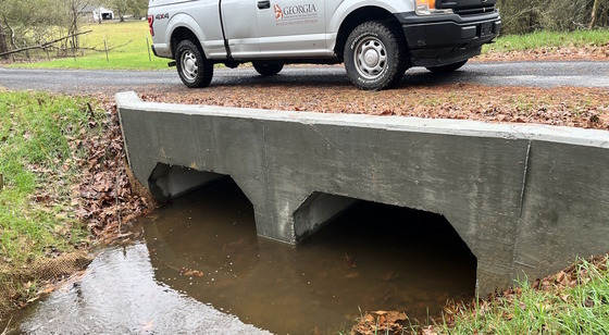 New open-bottom culvert with DNR truck parked on road above