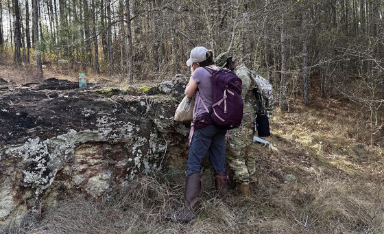 Two researchers study finds on a gray rock at Ohoopee Dunes WMA