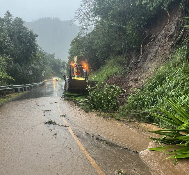 Public Works crews work to clear debris from the roadway on Hulemalu Road.