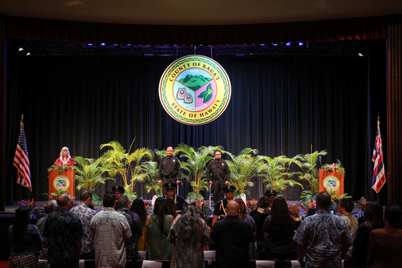 Chief Ke and Chief Tai on stage as Police Commission Vice Chair Mary Kay Hertog, serving as Master of Ceremonies, 