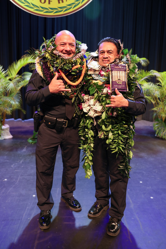 Outgoing Interim Chief Elliott Kalani Ke (left) and incoming Chief Rudy Tai (right) are honored with lei 