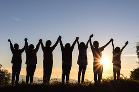 A group of people holding hands outside