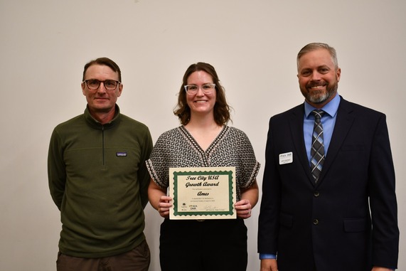 Three people holding a certificate