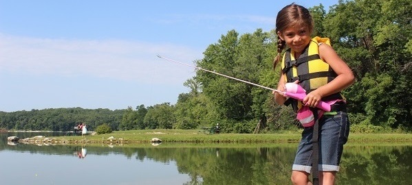 A girl fishing with a pink rod.