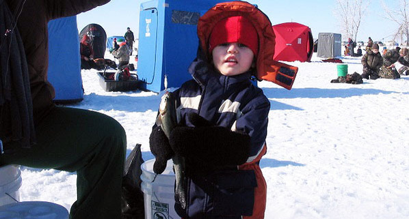 A young boy holding a trout he caught at a winter urban trout stocking.