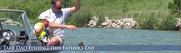A young son and father fishing from a boat.