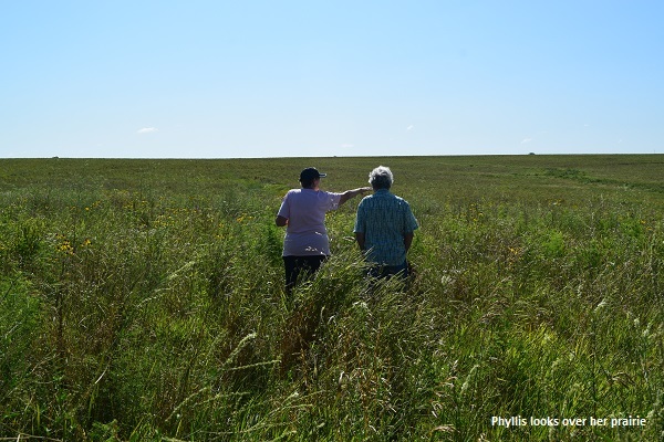 Phyllis Kimball shows of her prairie to a friend
