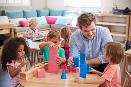 Preschool teacher at table with students