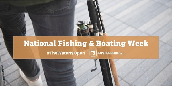 A woman carrying a fishing pole on a pier.