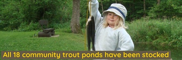 A young girl holding a stringer of trout.