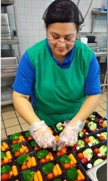School nutrition employee preparing food