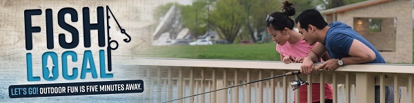 A couple fishing for a dock at at community fishing pond.