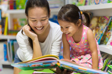 Teacher reading book with young student