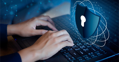 Graphic with hands typing on laptop with security shield image hovering over keyboard.